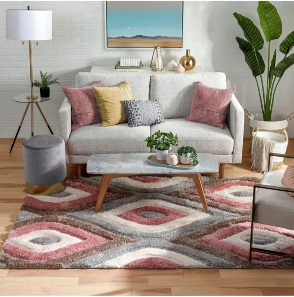 Pink, grey and cream wave-patterned carpet beneath a marble coffee table